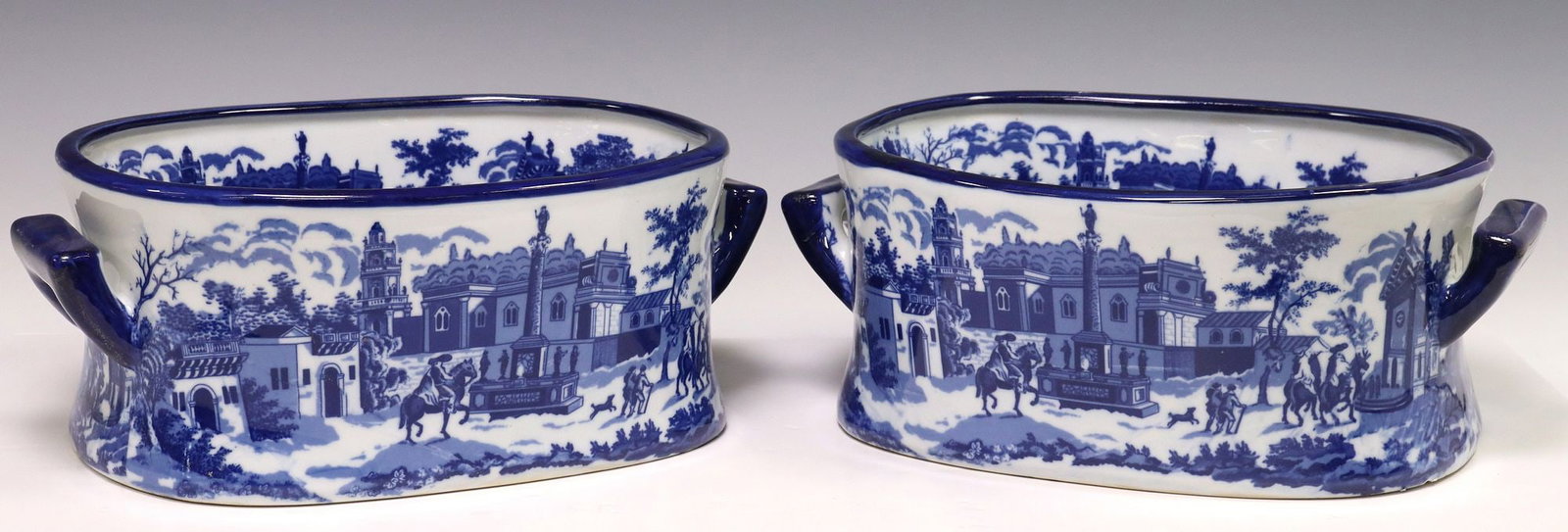 (2) BLUE & WHITE TRANSFERWARE STREET SCENE FOOTBATHS: (pair) Decorative blue and white transferware footbaths, late 20th c., with transfered street scene in a townscape, dual side handles, marked Victoria Ware underfoot, approx 5 5/8"h, 14