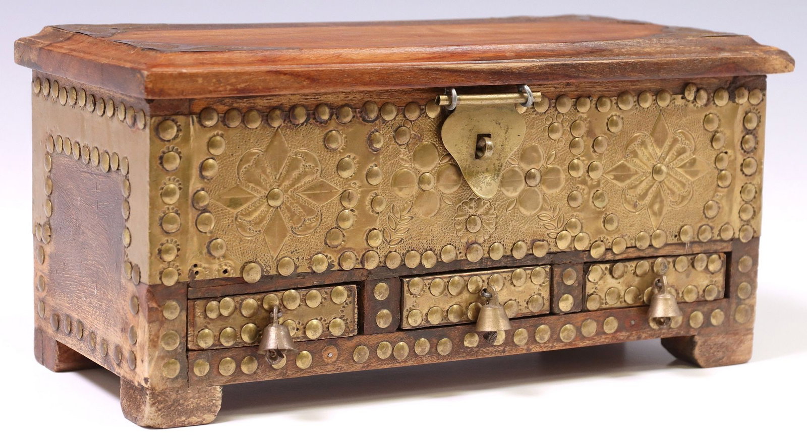 MINIATURE BRASS-MOUNTED TEAK KASHA ZANZIBAR CHEST: Miniature brass-mounted teak kasha chest, Zanzibar, hinged top opening to interior fitted with secret compartment at one side, over three small, shallow drawers, case mounted throughout with stippled 
