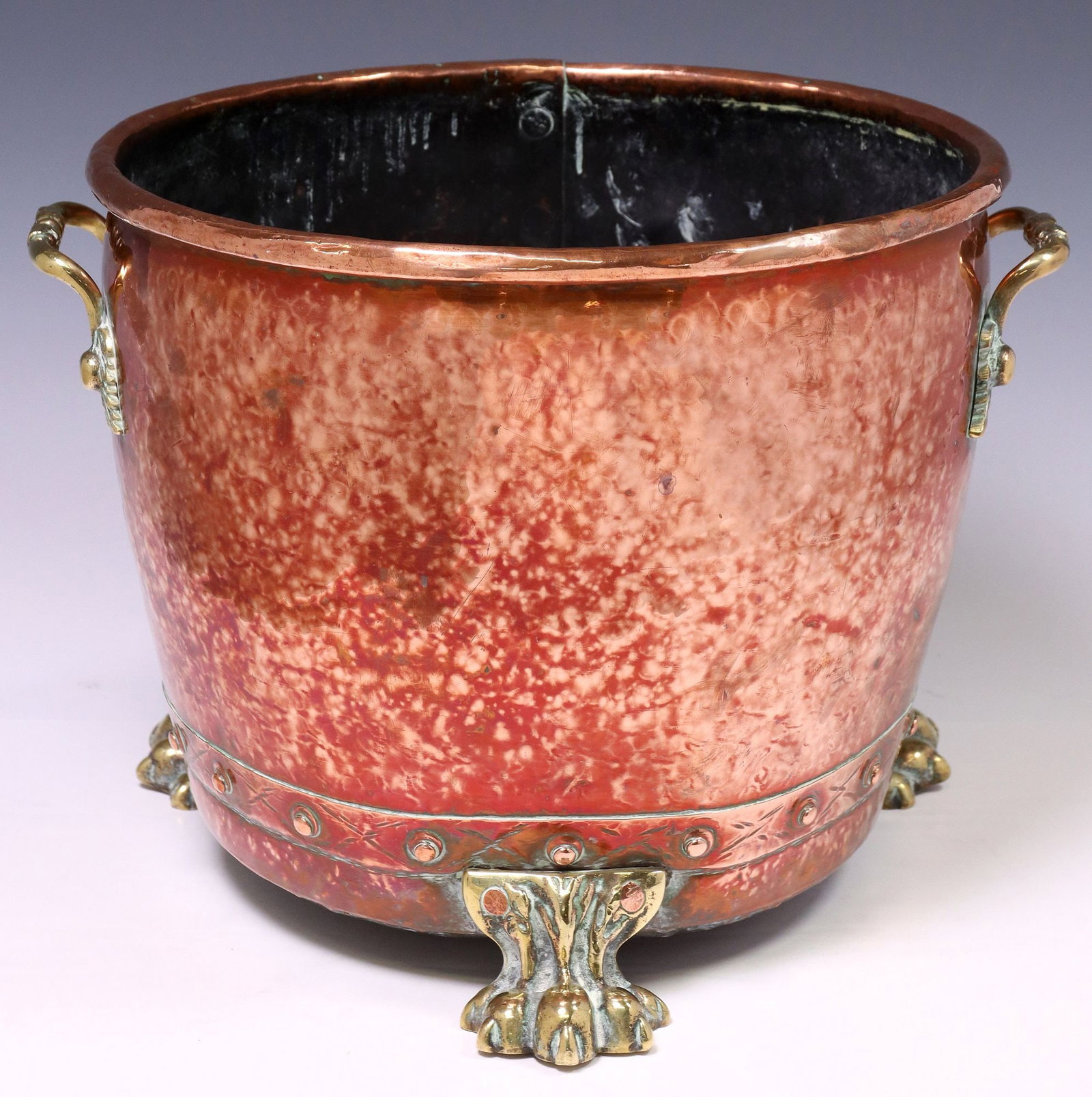 ENGLISH VICTORIAN BRASS & COPPER JARDINIERE / PLANTER: English Victorian brass and copper jardiniere/ planter, late 19th c., having tapered body with dual side handles, rising on paw feet, approx 11.75"h, 15.75"w, 13.75"d, 9.75lbs