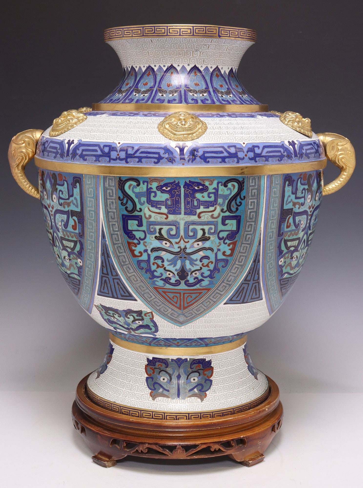 LARGE CHINESE ARCHAIC 'TAOTIE' CLOISONNE VASE ON STAND: Large Chinese cloisonne vase, of baluster form, with all-over polychrome enameled decoration of archaic taotie masks and stylized dragons on a fretworked white-ground, the shoulder encircled by g
