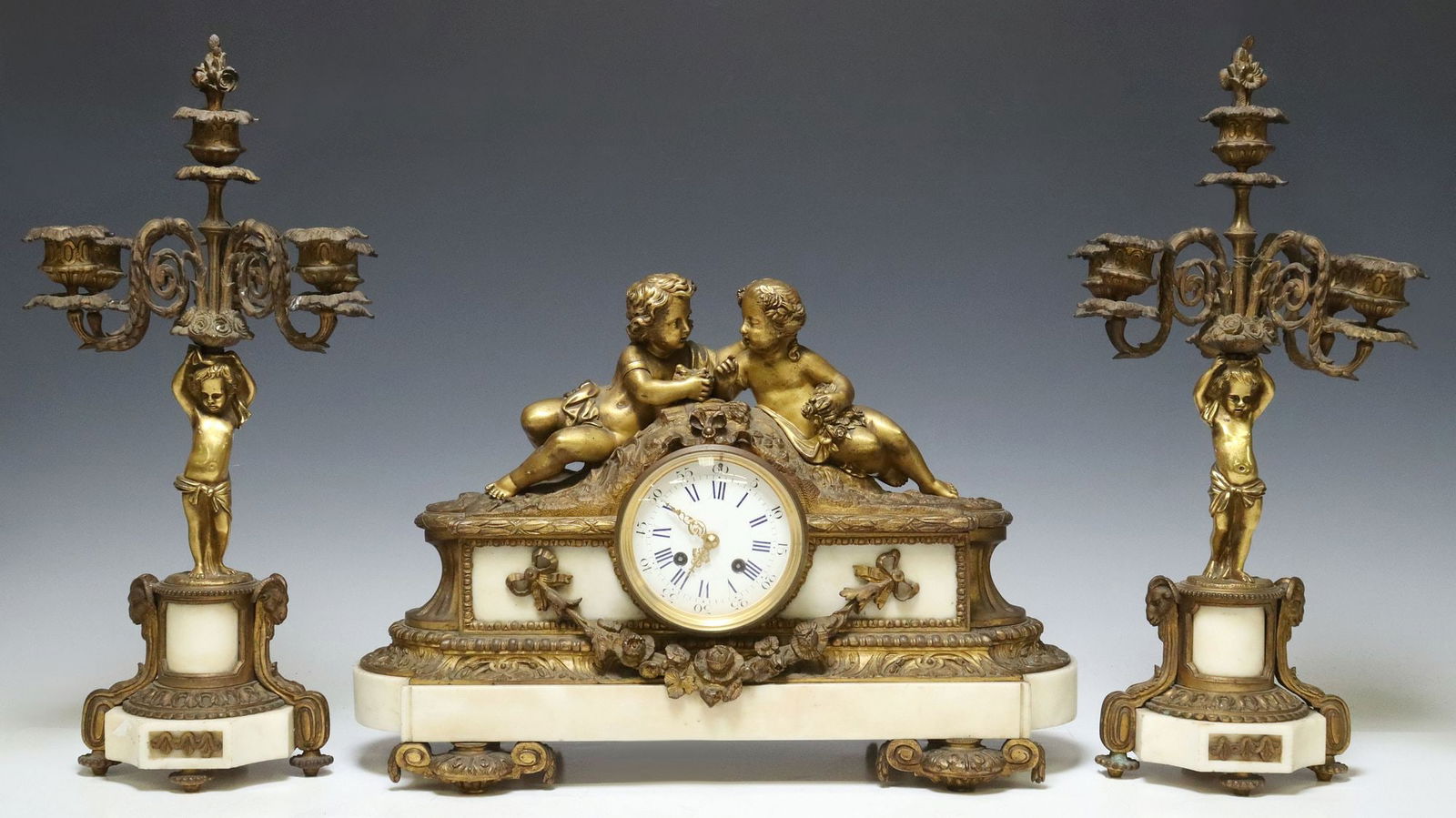 (3) FRENCH LOUIS XVI STYLE BRONZE & MARBLE CLOCK & CANDELABRA: (3 piece) French Louis XVI style bronze and marble mantel garniture set, 19th c., including: (1) shelf clock, figure group after the model by Jean-Jacques Feuchere (French, 1807-1852), white enamel di
