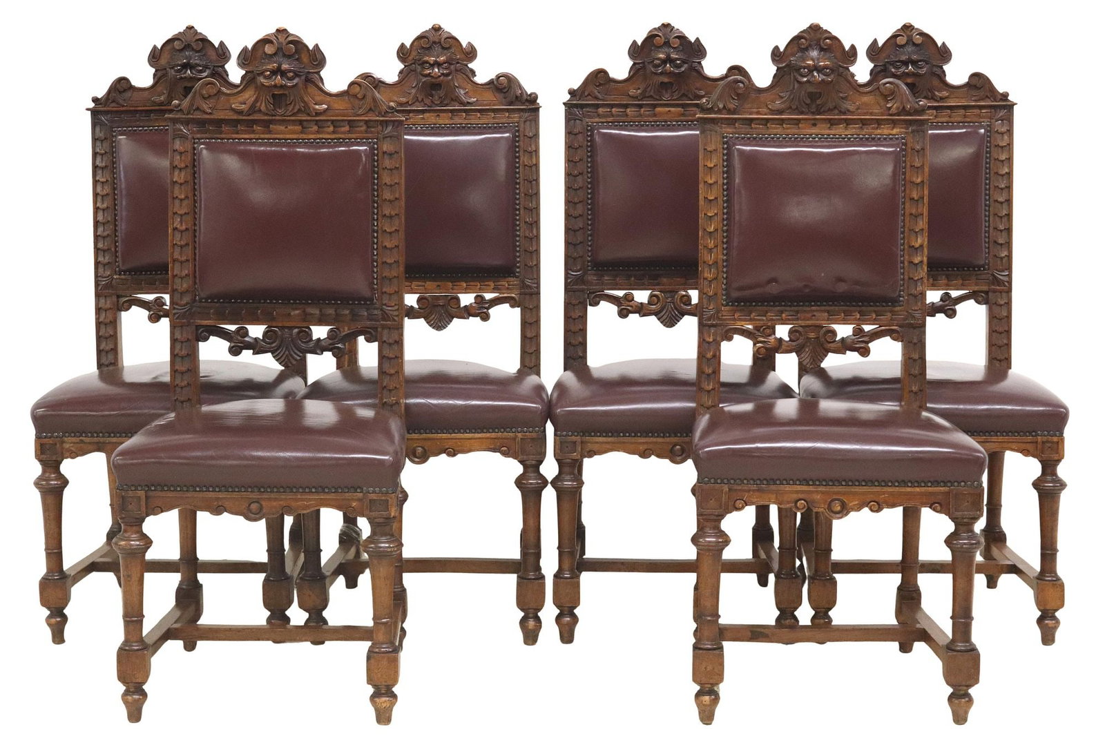 (6) ITALIAN RENAISSANCE REVIVAL CARVED WALNUT CHAIRS: (lot of 6) Italian Renaissance Revival walnut chairs, early 20th c., having carved grotesque mask crest, above padded back and seat in maroon upholstery with nailhead trim, turned supports joined by H