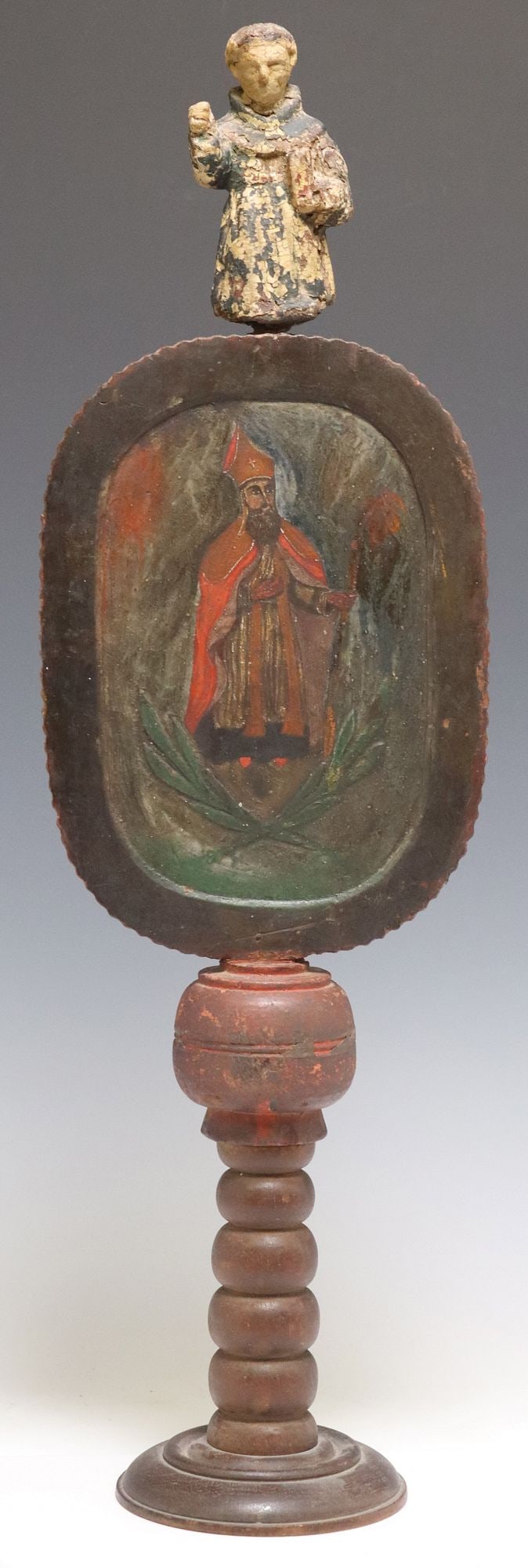 SPANISH COLONIAL STYLE SAN ISIDORO DE SEVILLE CARVED & PAINTED ALTARPIECE: Spanish Colonial style religious altar decoration, carved Santos figure in Franciscan robes with book, surmounting a painted portrait of Saint Isidore de Seville in oval frame, turned wood s