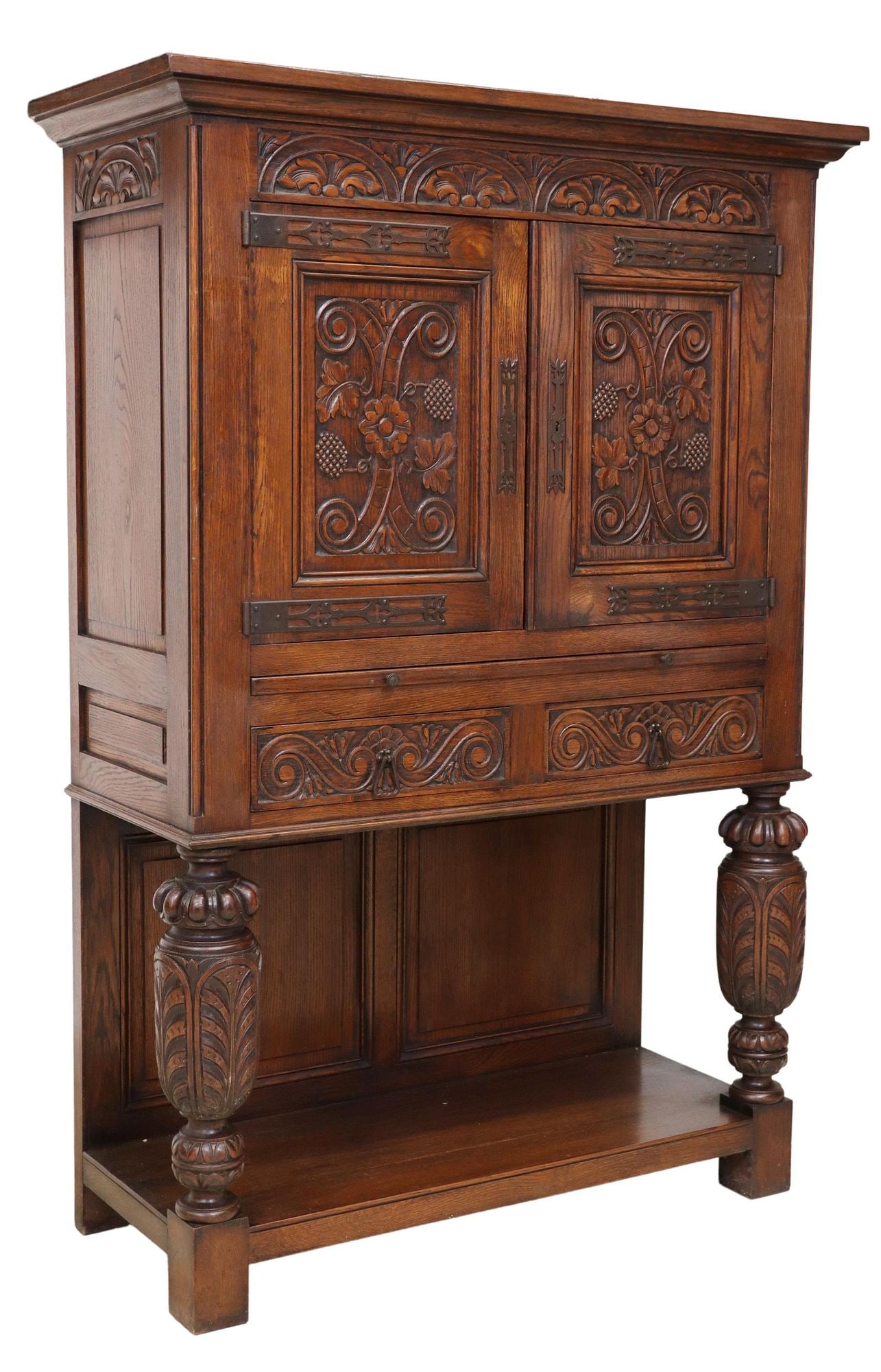 CONTINENTAL RENAISSANCE REVIVAL CARVED OAK BUFFET: Continental Renaissance Revival carved oak buffet, late 19th c., having dual cabinet doors with floral medallions and grape vine motifs, revealing shelved interior with mirrored back panel, single pul