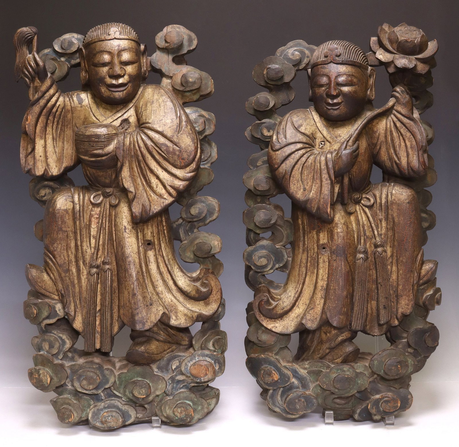 (2) CHINESE CARVED HARDWOOD ARCHITECTURAL BUDDHIST FIGURES: (lot of 2) Chinese carved hardwood figures/ architectural elements, each with remnants of polychrome paint, central enrobed figure, (one) holding a fly whisk and bowl, (one) holding a lotus flower, am
