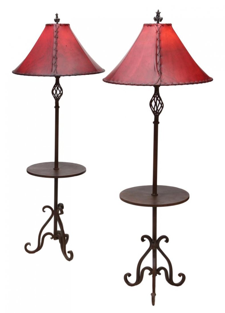 (PAIR) WROUGHT IRON LEATHER SHADE FLOOR LAMPS: (pair) Wrought iron floor lamps with red leather shades, a circular table on the vertical standard, all rising on scrolled feet, 65.5"h, 16"d Start Price: $150.00