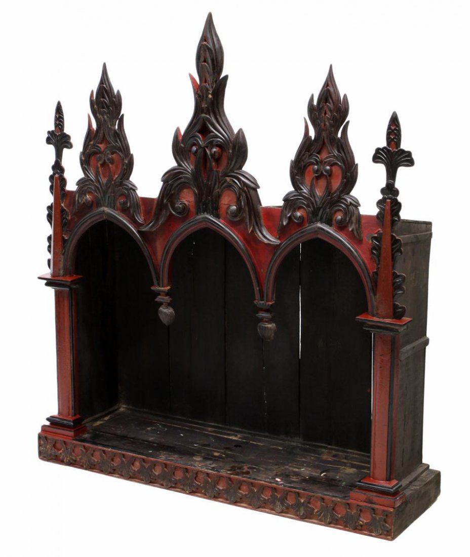 LARGE FRENCH COLONIAL GOTHIC STYLE ALTAR NICHE: Large French Colonial wood altar niche in the Gothic taste, c. 1900, three crests flanked by spires, rising above three lancet arches, the whole in a red lacquer finish with black accents, restoration