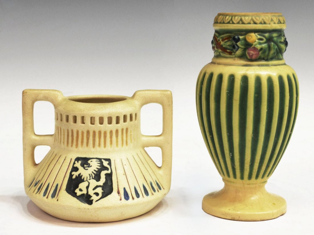 (2) WELLER ART POTTERY CREAMWARE VASE GROUP: (lot of 2) Weller art pottery vases, comprising: (1) creamware and green fluted vase, ribbed body, floral motif around neck 7.25"h; (1) double handled creamware vase with a shield depicting a lion ram