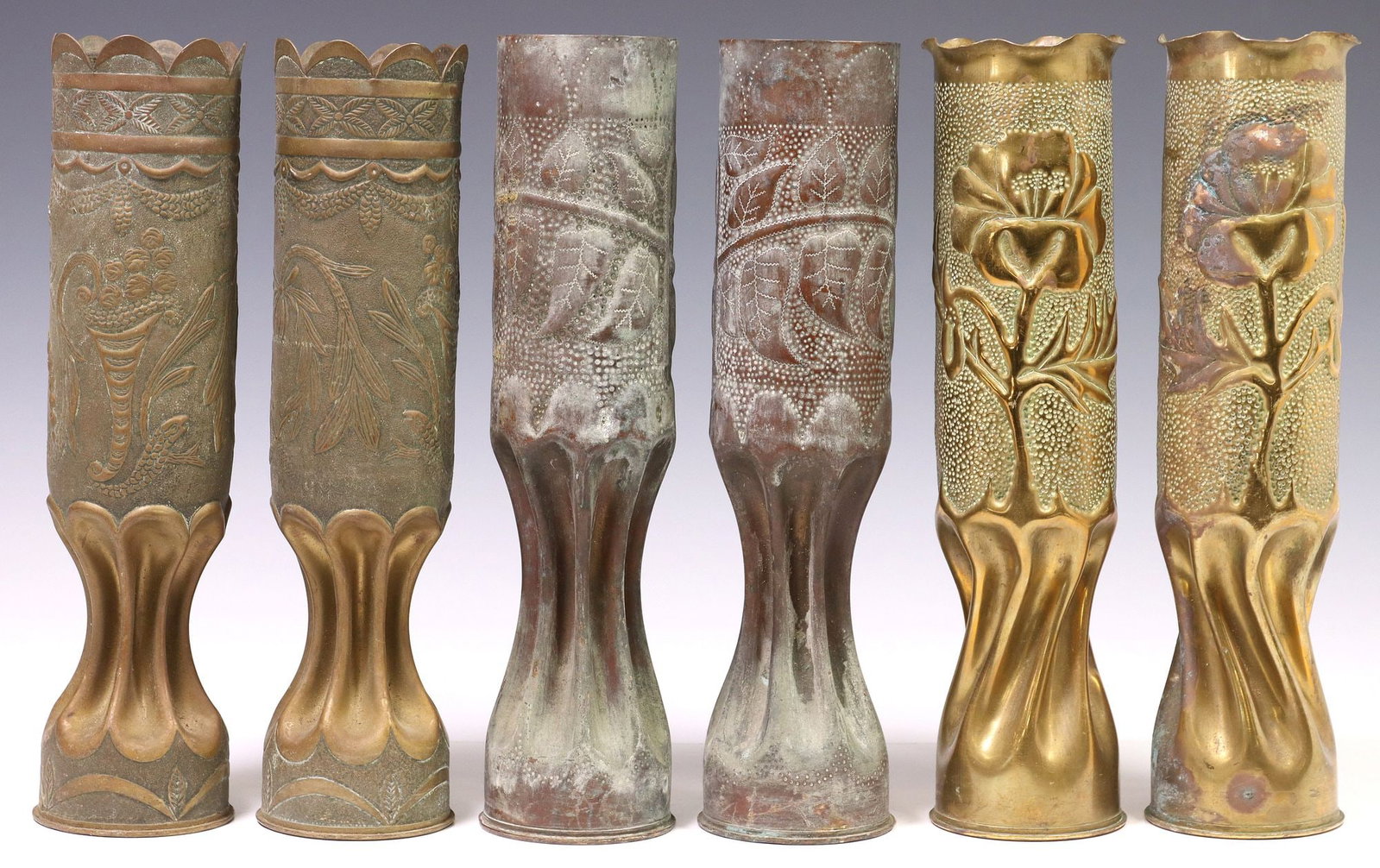 (6) FRENCH WWI-ERA TRENCH ART ARTILLERY SHELL VASES: (lot of 6) French WWI-era trench art vases, fashioned from artillery shells, each rising on waisted stem, including: (2) having scalloped rim, over foliate wreaths and cornucopia motifs in low relief,