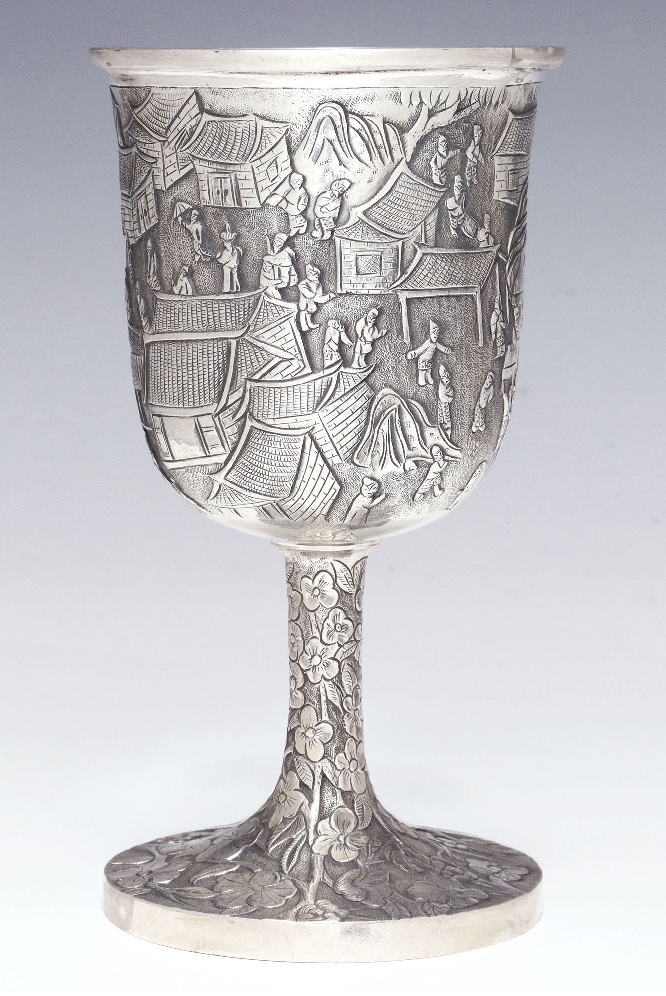 CHINESE EXPORT SILVER GOBLET RETAILED BY KWONG HING LOONG: Chinese Export .900 silver goblet, retailed by Kwong Hing Loong & Company (fl.1880-1920), Hong Kong and Singapore, slightly tapering bowl chased with figures in a landscape, stem and foot decorate