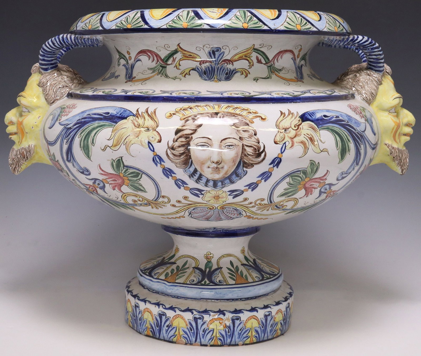 LARGE CONTINENTAL MAJOLICA URN-FORM JARDINIERE: Continental majolica jardiniere, tin glazed, decorated with grotesques, rocaille and foliate scrolls, handles modeled as satyr masks, intact with staple repair to base, approx 17.5"h, 22&quo