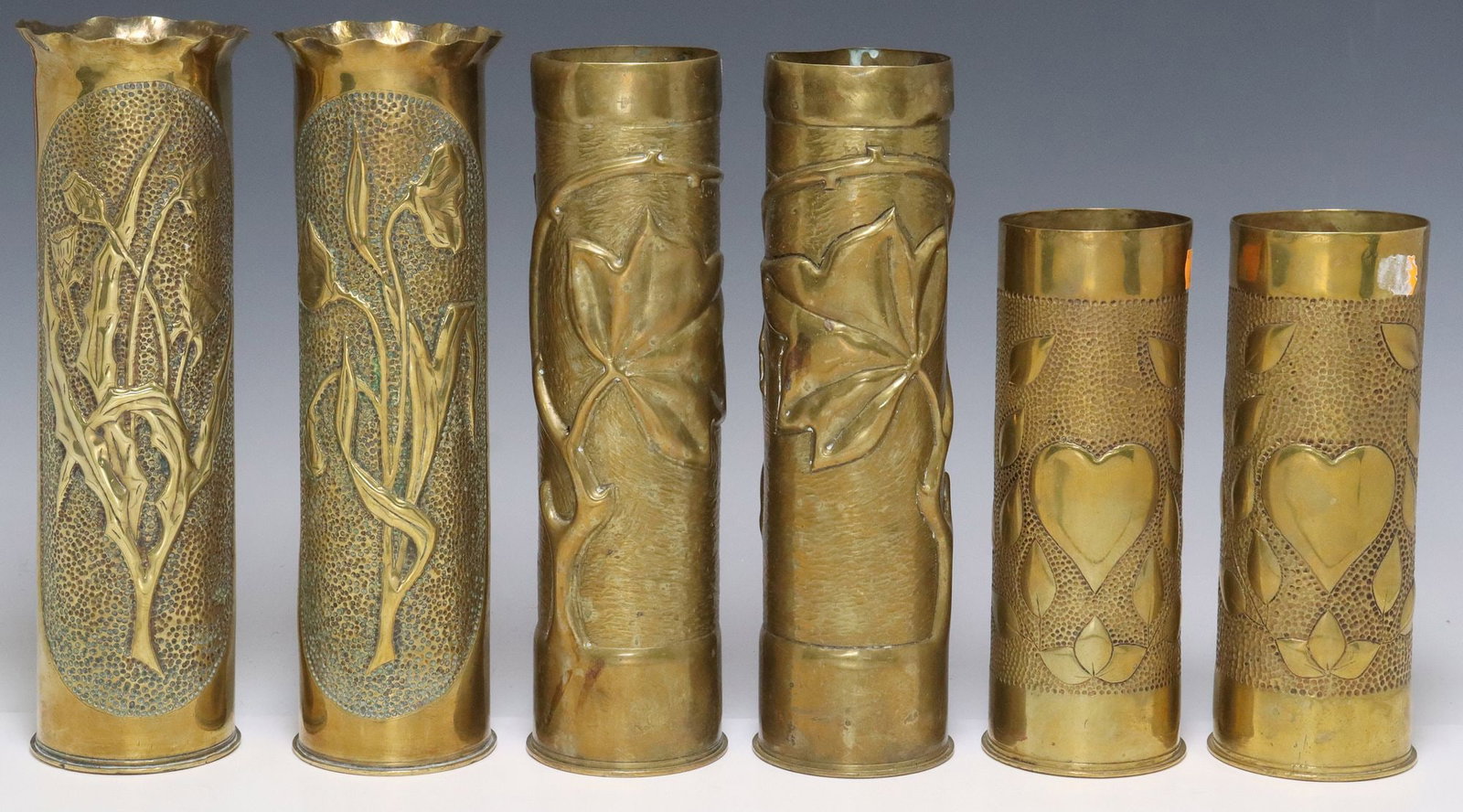 (6) FRENCH WWI-ERA TRENCH ART ARTILLERY SHELL VASES: (lot of 6) French WWI-era trench art vases, fashioned from artillery shells, including: (2) having flared and scalloped rim, central repousse flower, (2) with raised foliates on textured ground, (2) d