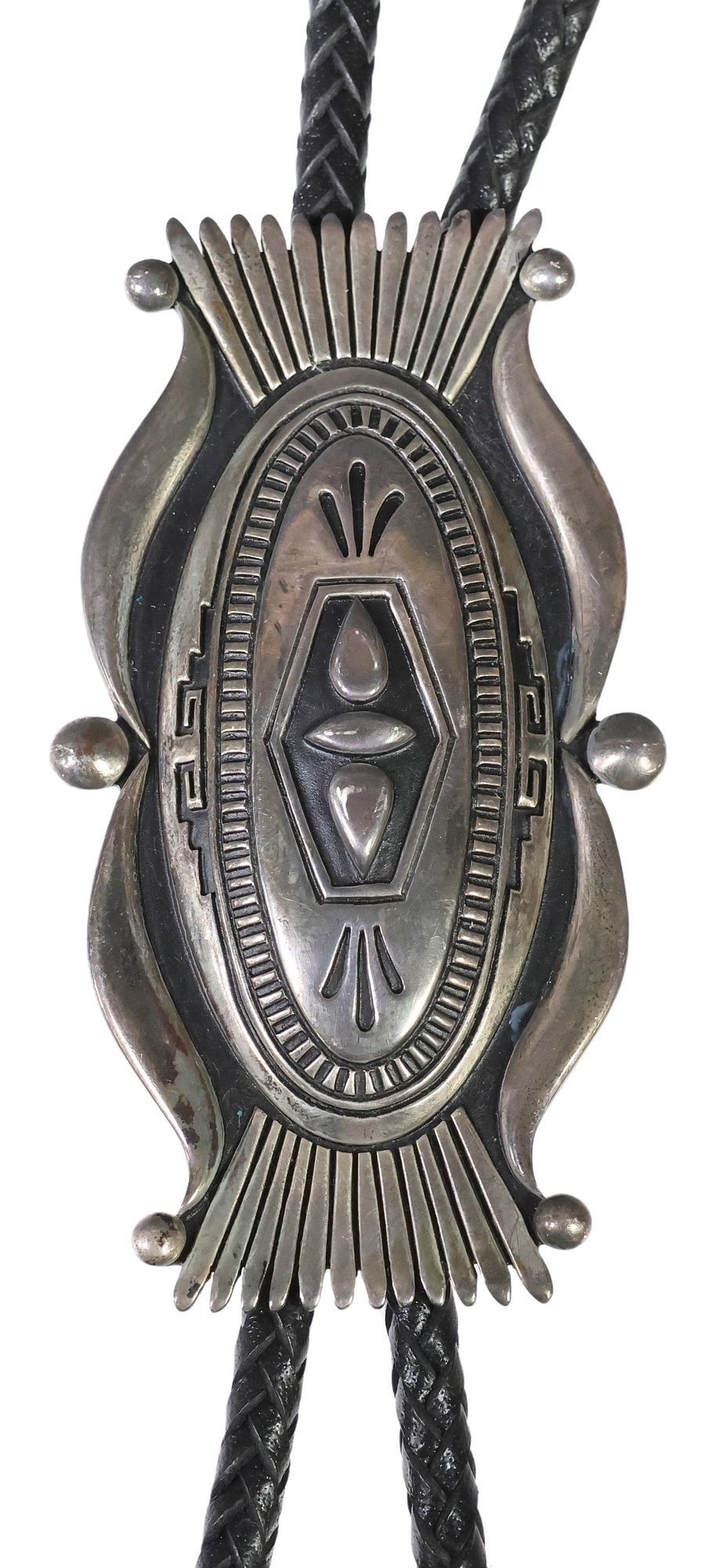 STEVEN J. BEGAY NAVAJO STERLING SILVER OVERLAY BOLO TIE, 3.5"H: Large Native American sterling silver overlay bolo tie, signed SJB (Steven Begay, Navajo/ Dine, 20th c.), shaped ornament with repeating geometric designs, bolo hallmarked sterling to reverse, bo