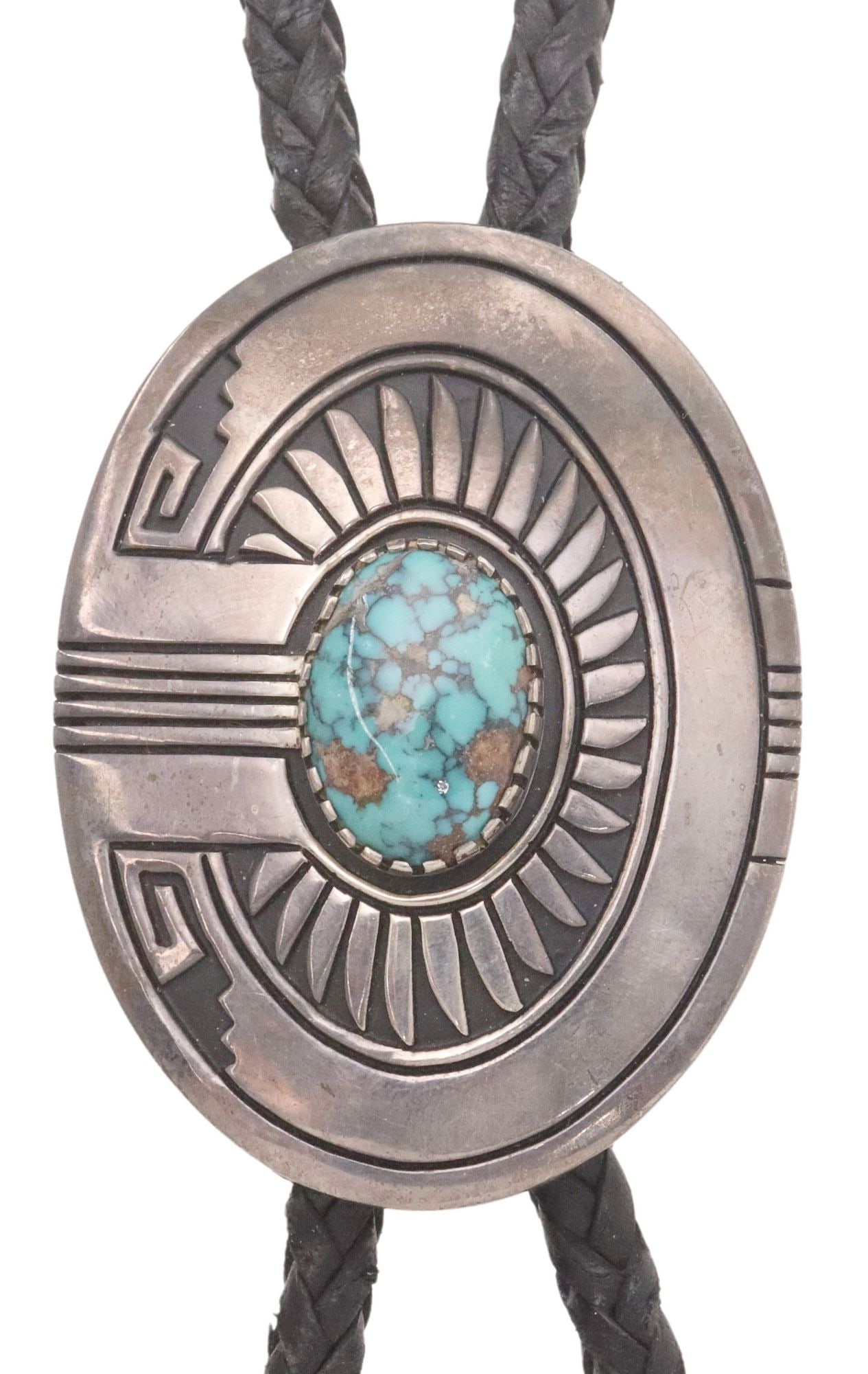 STEVEN J. BEGAY NAVAJO SILVER OVERLAY & TURQUOISE BOLO TIE: Native American sterling silver bolo tie, Steven J. Begay (Navajo/ Dine, 20th c.), silver overlay hollow plaque, oval cabochon turquoise, silver sleeves and bolo tips, braided black leather cord,
