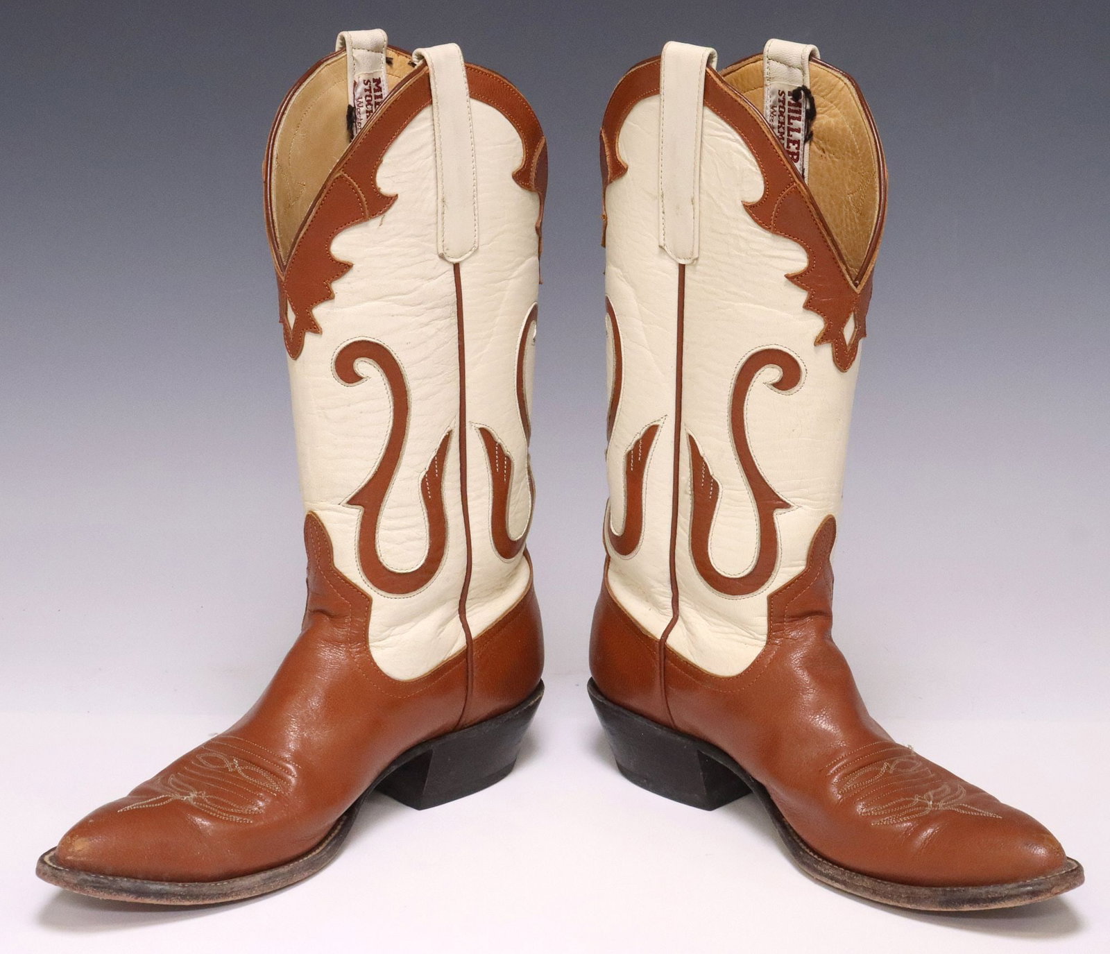 (2) LADIES MILLER STOCKMAN TWO-TONE COWBOY BOOTS & COWHIDE RUG: (lot of 2) Western boots and cowhide rug, including: (pair) Women's Miller Stockman two-tone leather cowboy boots, having white shaft with stitched brown trim, stamped 6796C 2650 to shaft interior