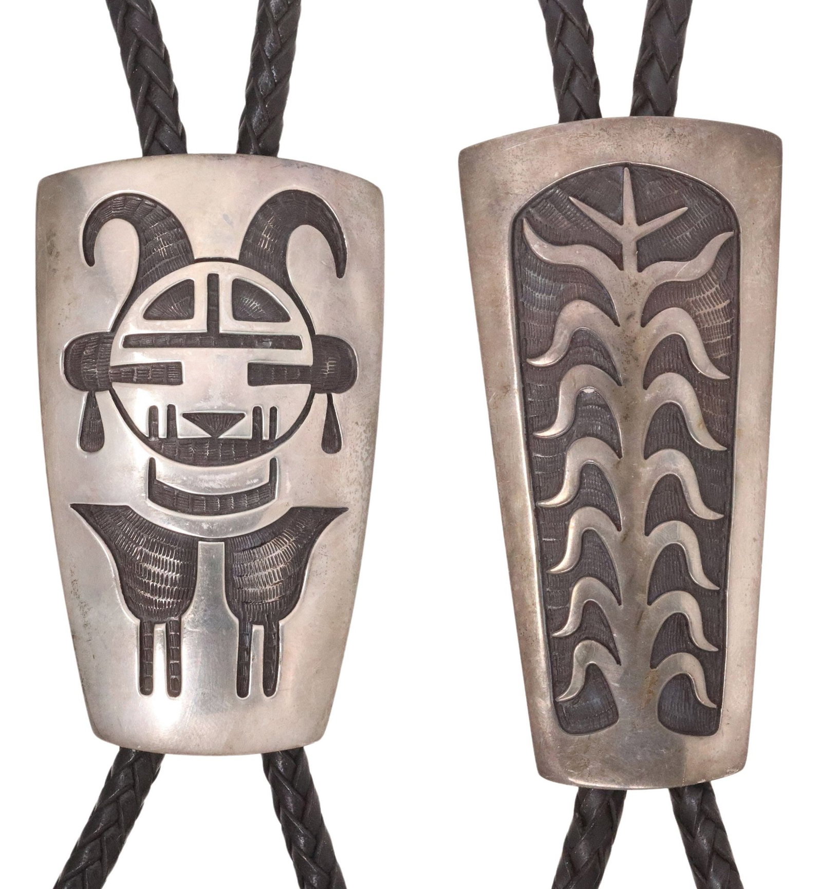 (2) BERNARD DAWAHOYA (1935-2011) HOPI SILVER OVERLAY BOLO TIES: (lot of 2) Native American silver (content unknown) overlay bolo ties, Bernard Dawahoya (Hopi Pueblo, 1935-2011), each having tapered rectangular ornament, silver tips, on braided black leather c