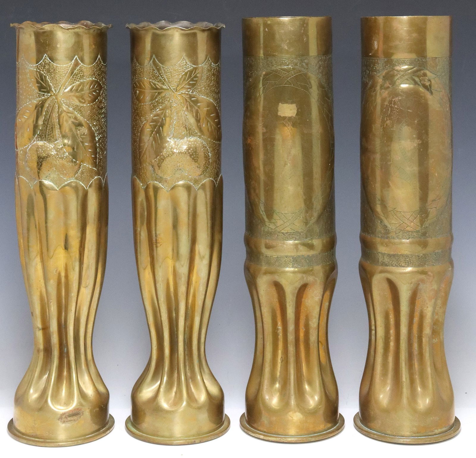 (4) LARGE FRENCH WWI-ERA TRENCH ART ARTILLERY SHELL VASES, 19.75"H: (lot of 4) Large French WWI-era trench art vases, fashioned from artillery shells, each rising on waisted stem, including: (2) with repousse fruit branch on dotted ground, (2) having incised foliates,