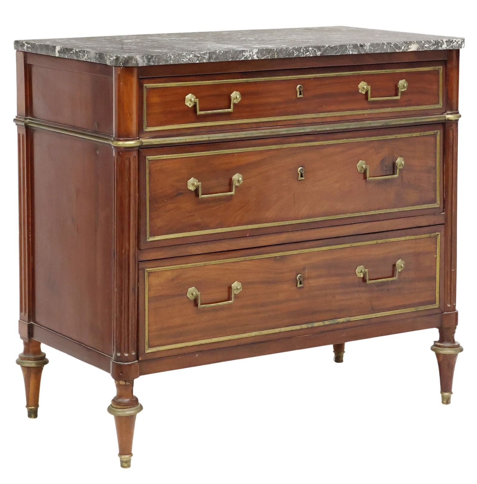 FRENCH LOUIS XVI STYLE MARBLE-TOP MAHOGANY COMMODE: French Louis XVI style mahogany commode, late 19th c., having shaped marble top, over case with protruding fluted corner posts, three drawers with gilt metal trim, rising on brass-capped tapered