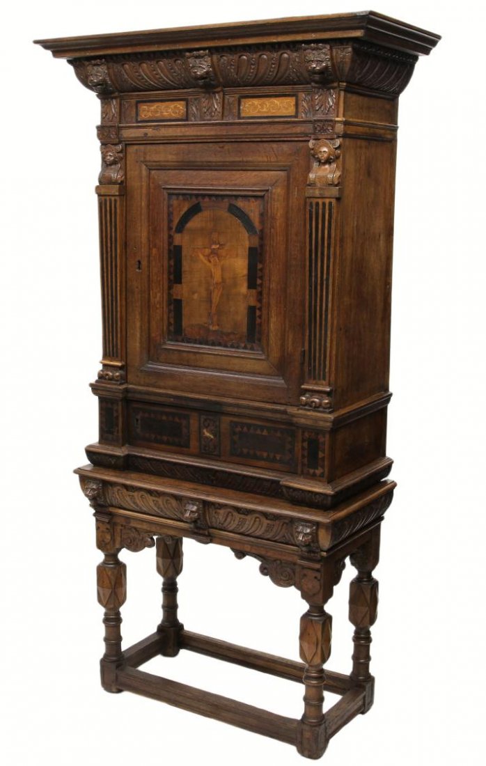 ANTIQUE FLEMISH RELIGIOUS VESTRY CARVED CABINET: Flemish Renaissance style vestry cabinet, 18th c., a stepped cornice with carved frieze with contrasting wood inlay, pilaster figural mounted columns flanking a central door with an inlaid depiction o