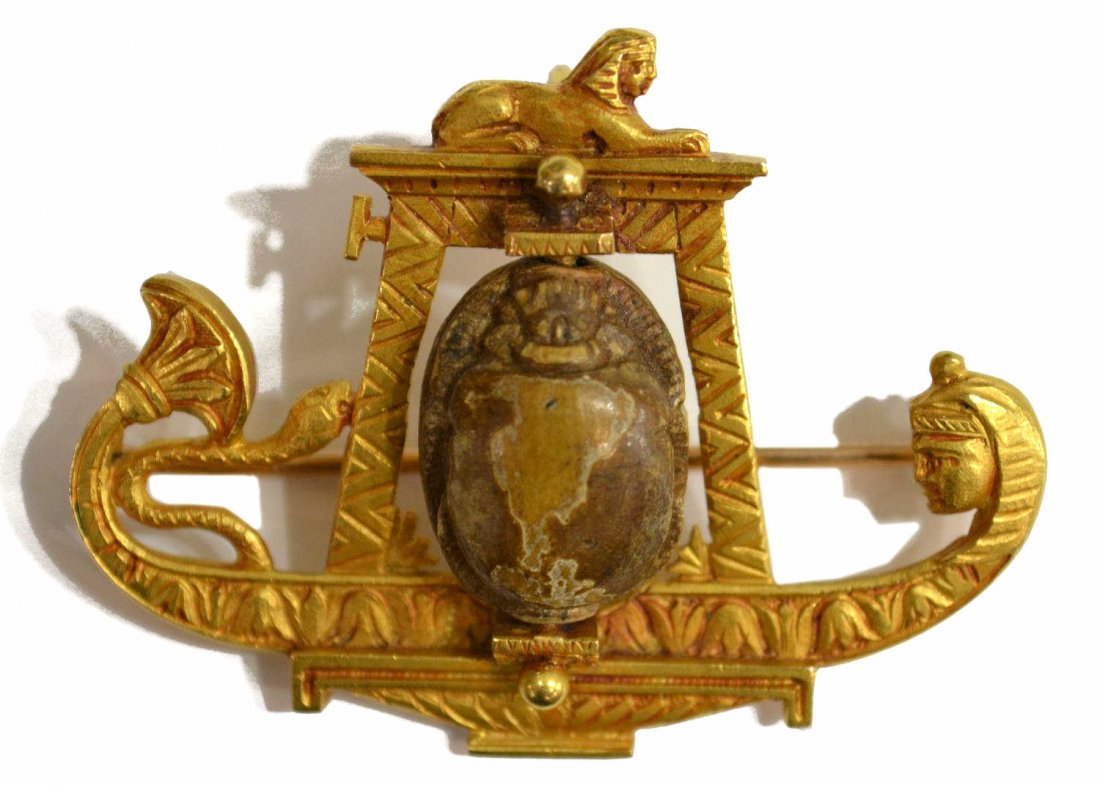 FINE ANTIQUE EGYPTIAN REVIVAL 18KT & SCARAB BROOCH: Egyptian Revival estate pendant / brooch, 18kt gold figural frame in a high carat wash, centering a rotating scarab, possibly ancient, unmarked, 1.5"h, 1.75"w, 13.7 grams (all inclusive) Start Price: 