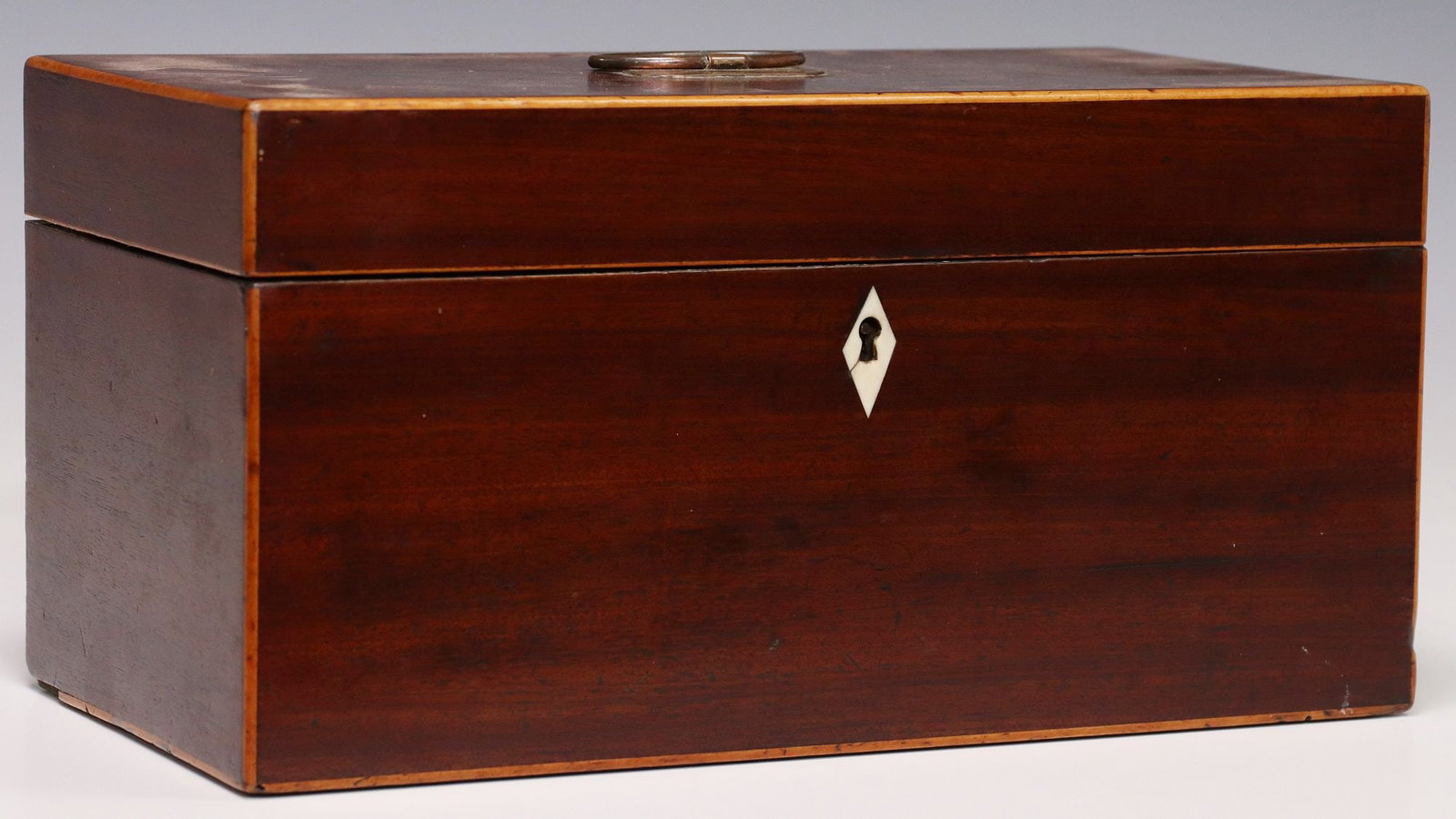 ENGLISH REGENCY PERIOD INLAID MAHOGANY TEA CADDY: English Regency mahogany tea caddy, early 19th c., rectangular case with inlaid string trim and diamond-form bone escutcheon, hinged lid with central metal handle, opening to divided interior, fitted 