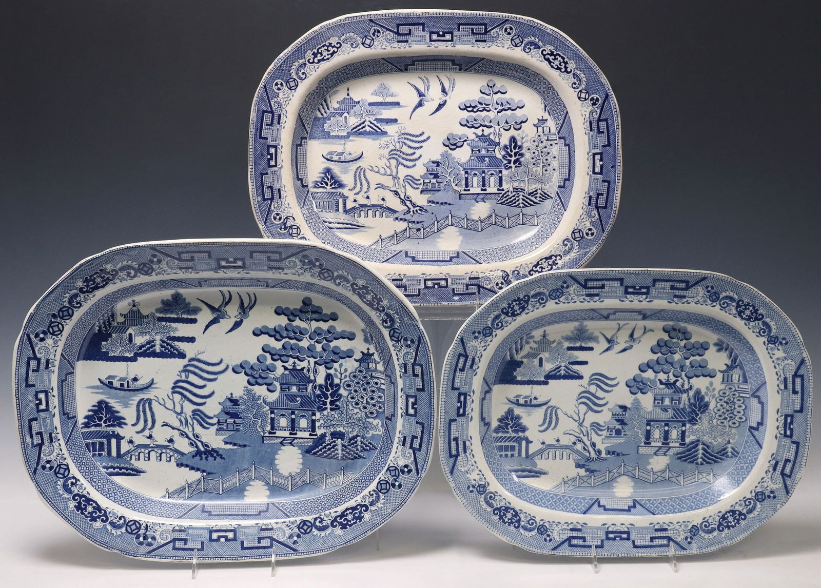 (3) ENGLISH STAFFORDSHIRE IRONSTONE 'BLUE WILLOW' PLATTERS: (lot of 3) English Staffordshire ironstone service platters, in the "Blue Willow" pattern, each with blue and white transferred Chinoiserie designs, various marks and makers, largest: approx