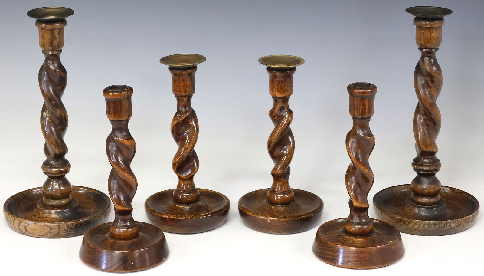 (6) ENGLISH CARVED OAK BARLEY TWIST CANDLESTICKS, 3 PAIRS: (lot of 6) English carved oak barley twist candlesticks, early 20th c., in three pairs, each retaining metal bobeche liner, largest: approx 10.5"h, 5.25"diam, smallest: approx 8"h, 4&qu
