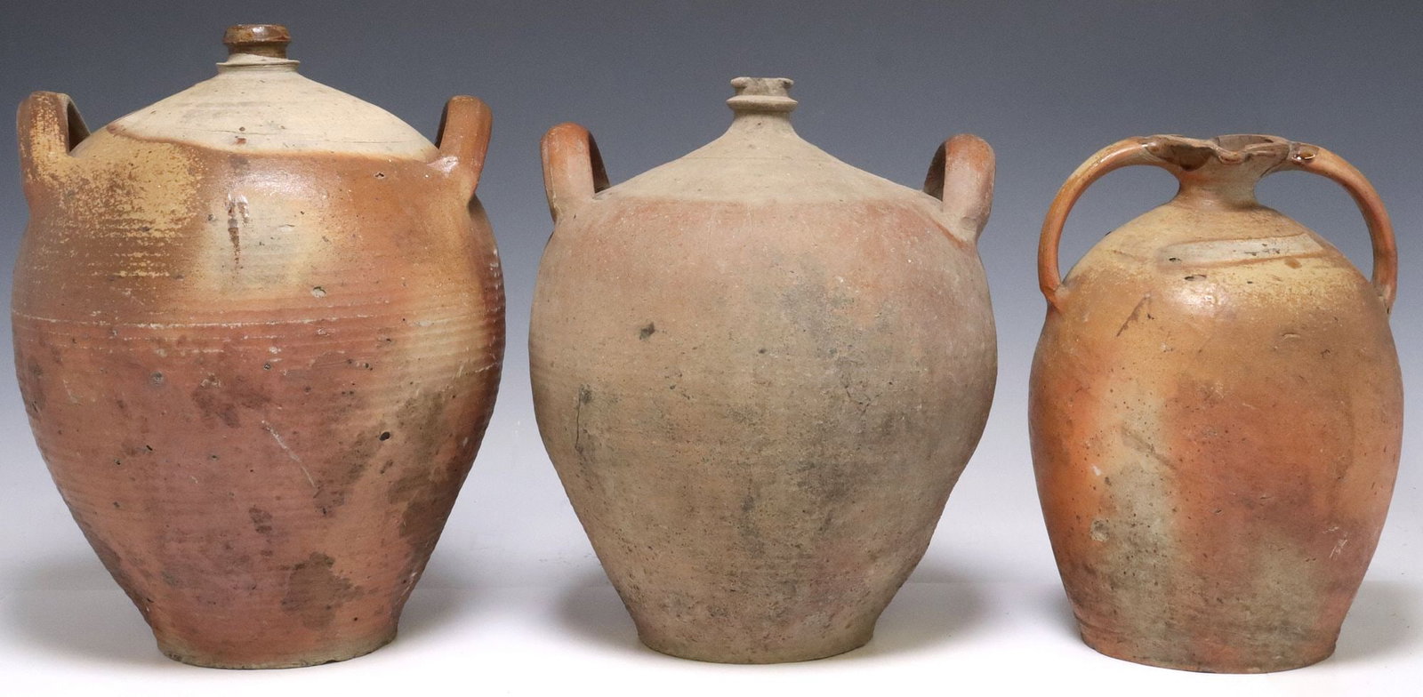 (3) FRENCH PROVINCIAL STONEWARE OIL JUGS & WATER PITCHER: (lot of 3) French Provincial stoneware vessels, including: (2) oil jugs, each with narrow spout over tapered body, (1) pitcher/ water jug, having dual rolled handles and pinched spout, largest: approx
