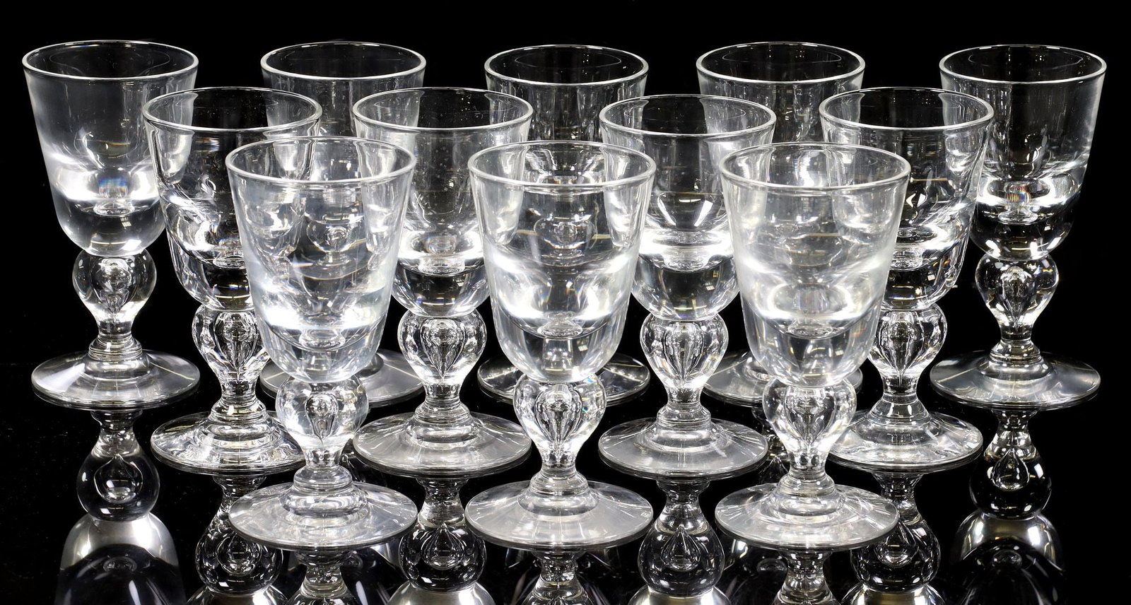(12) STEUBEN ART GLASS '7877' TEAR DROP CLARET WINE GLASSES: (lot of 12) Steuben art glass claret wine glasses, in the "7877" tear drop pattern, each rising on bulbous stem with central controlled bubble, bearing engraved maker's mark underfoot, all retaining S