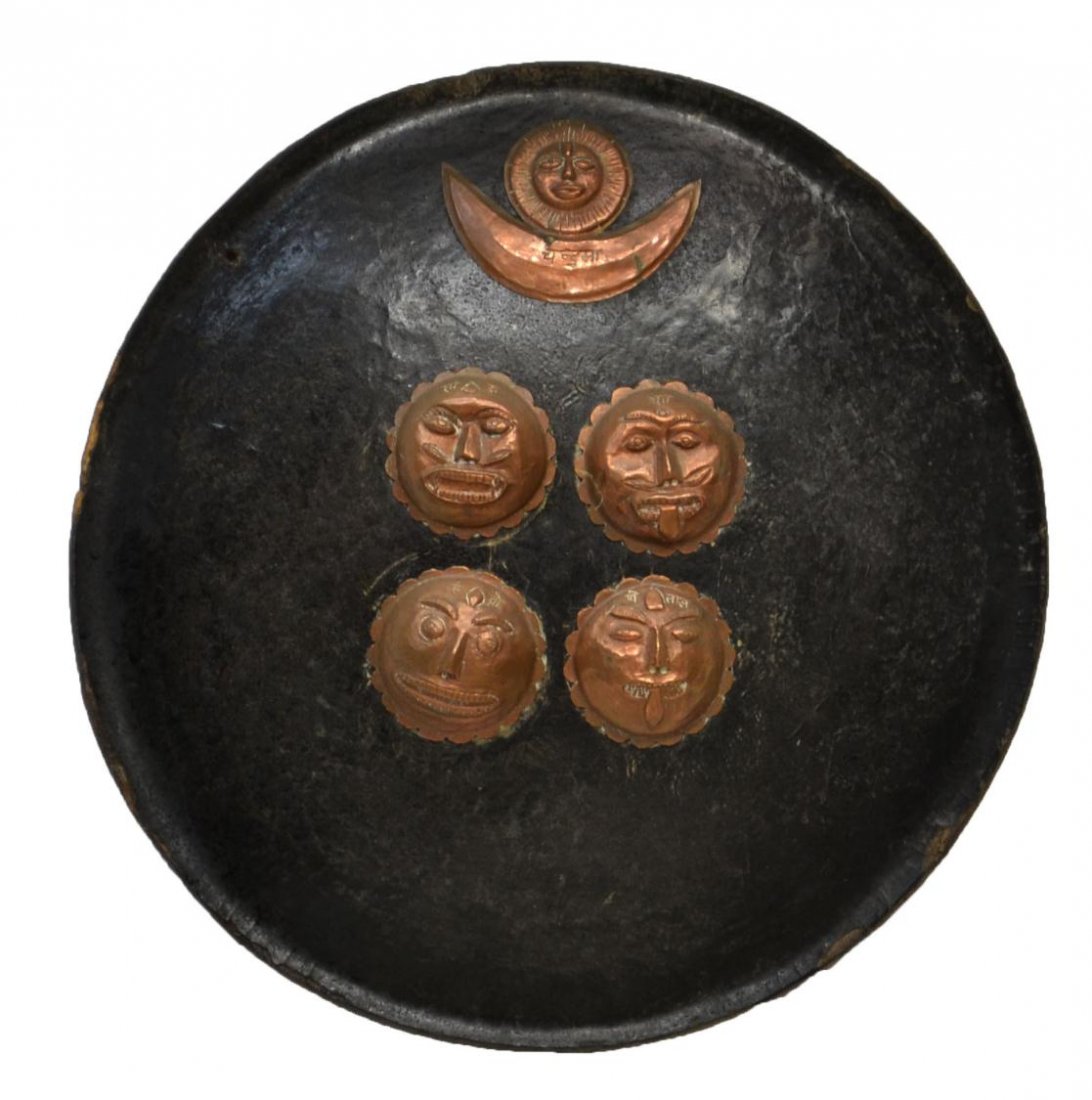 NEPAL RHINO SHIELD, EX UNIVERSITY EXHIBITION: Nepalese shield, 18th/19th century, a circular convex form covered with rhinoceros leather, at the front the Nepal symbol of sun over moon and four Buddhist faces all in copper with written characters