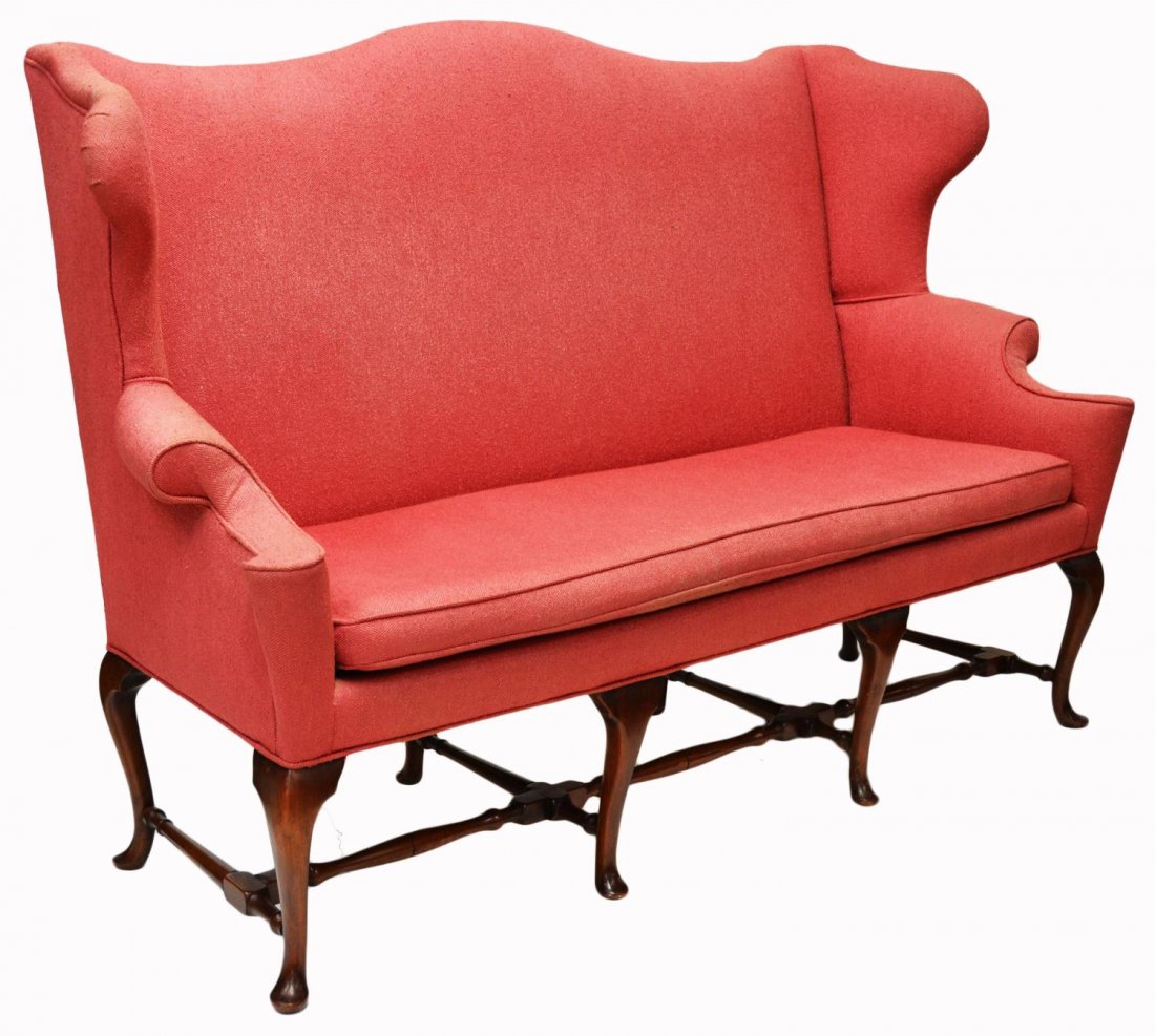 QUEEN ANNE STYLE UPHOLSTERED WINGBACK SETTEE SOFA: Queen Anne style wingback settee having a long loose cushion and rolled arm, cabriole supports joined by stretchers, upholstery with slight wear/fading, approx 44"h, 65"l, 22"d Start Price: $300.00