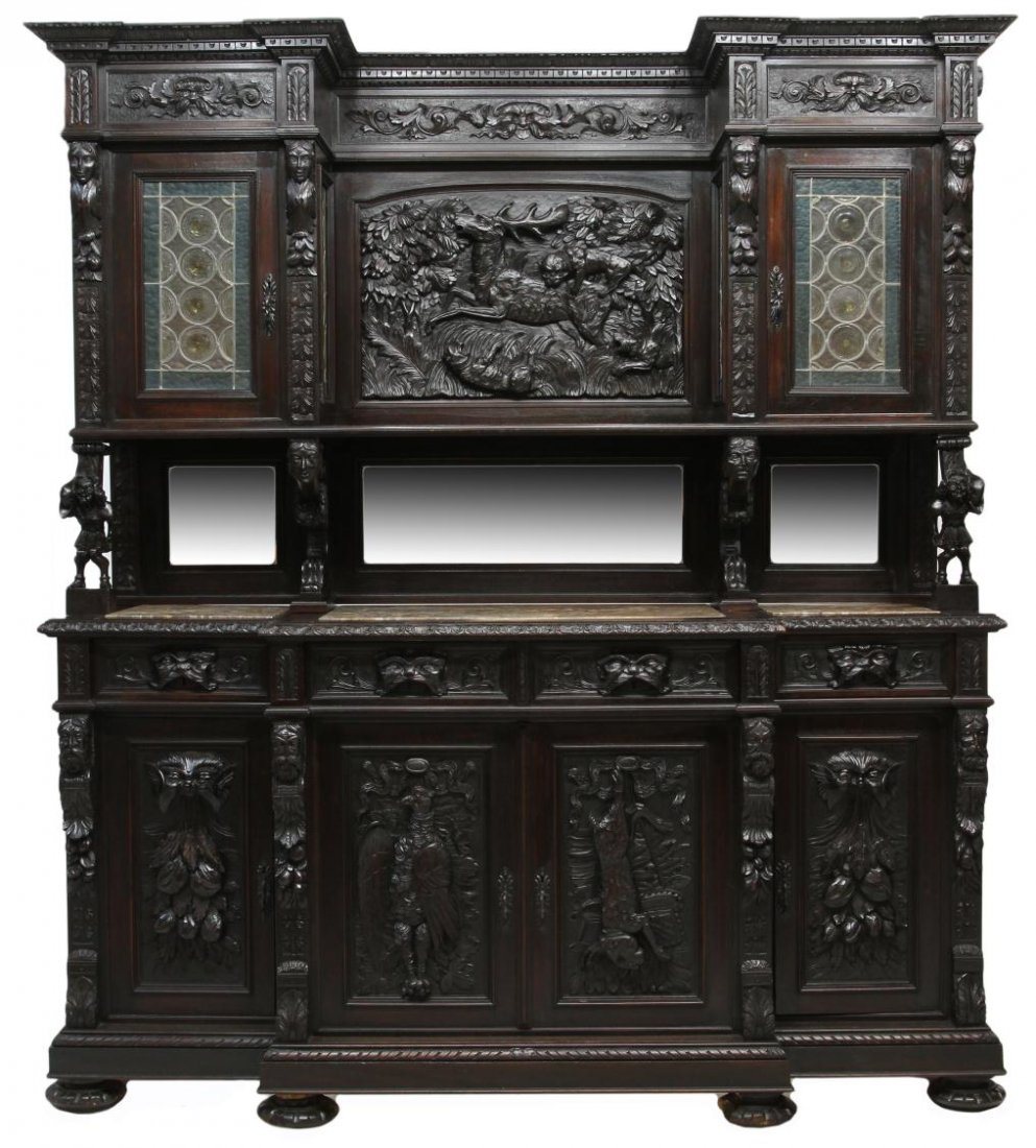 ANTIQUE ITALIAN STAINED GLASS CARVED HUNT CUPBOARD: Italian Renaissance Revival ebonized hunt cupboard, c. 1890, profusely decorated with relief carving including a large hunt scene, masks and grotesque figures, game animals, the upper part with flanki