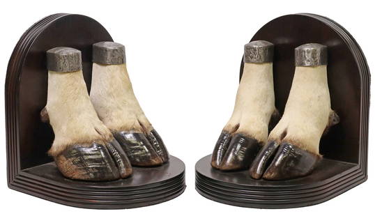 (2) TAXIDERMY ELAND ANTELOPE HOOF DEMILUNE BOOKENDS: (pair) Taxidermy eland antelope hoof bookends, each having ebonized demilune wood frame, supporting a pair of cloven hooves with silver-tone metal mounts, with black felt backing, approx