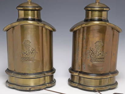 (2) ENGLISH BRASS TEA-CANISTER TABLE LAMPS: (pair) English brass tea canister form table lamps, 20th c., having crown and thistle flower motifs to body, ending on shaped base, accompanied by fabric shades, observed operating, lamp: approx 22.25