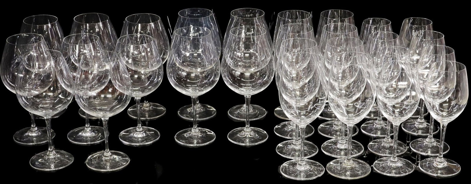 (28) RIEDEL COLORLESS GLASS STEMWARE: (lot of 28) Riedel colorless glass drinkware, all bearing acid-etched maker's mark underfoot, including: (4) 'New World' pinot noir stems, approx 9.25"h, 4.25"diam; (4) pinot noir stems, approx 8.5"h,