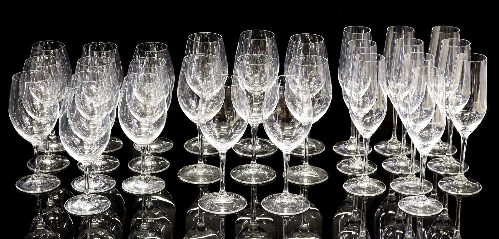 (28) RIEDEL COLORLESS GLASS STEMWARE, CHAMPAGNE & WINE GLASSES: (lot of 28) Riedel colorless glass stemware, all with acid-etched maker's mark underfoot, including: (8) sauvignon blanc/ white wine stems, approx 8 1/8"h, 3"diam; (10) champagne glasses, approx 8 7/8