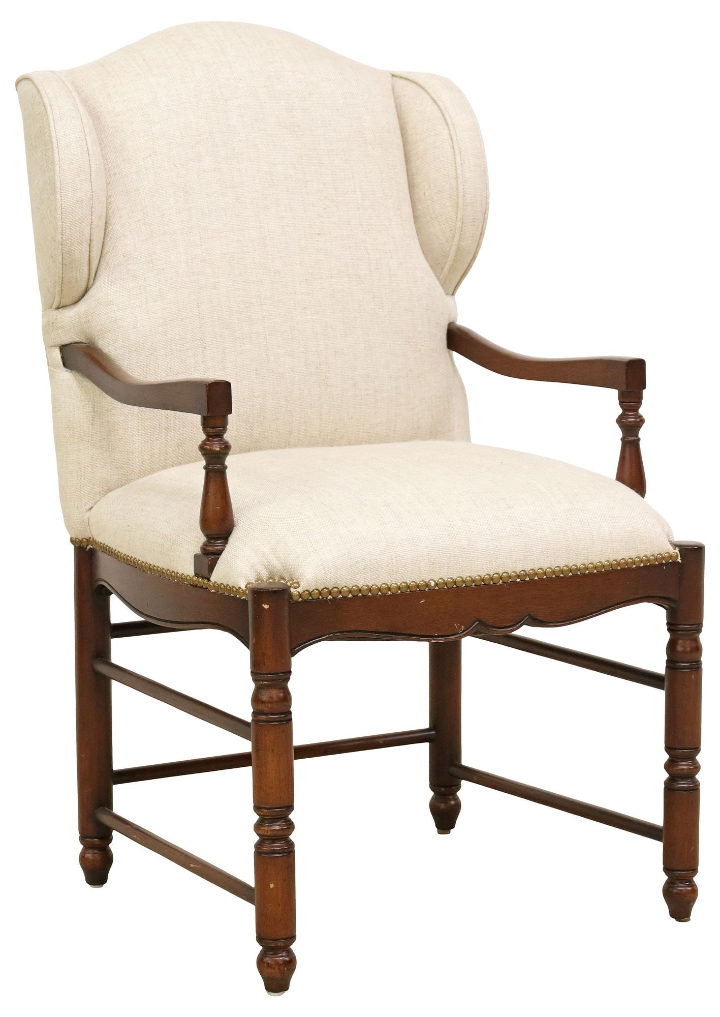 WILLIAM & MARY STYLE UPHOLSTERED WINGBACK ARMCHAIR: William and Mary style wingback armchair, 20th c., in beige fabric upholstery, with nailhead trim, curved armrests, rising on stretcher-joined turned supports, approx 40"h, 23"w, 21"d, seat height: ap