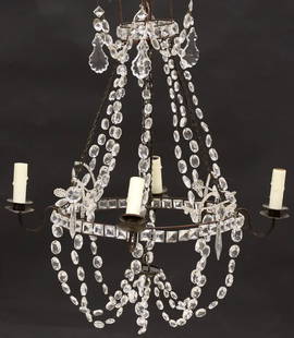 EMPIRE STYLE PATINATED METAL & CRYSTAL TIERED 4-LIGHT CHANDELIER: Empire style patinated metal and crystal four-light chandelier, 20th c., having tiered tapering frame issuing four scrolled arms, terminating on faux candles, hung with beaded crystal swag and faceted
