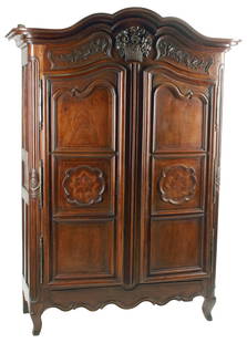 FRENCH PROVINCIAL INLAID WALNUT ARMOIRE, 18TH C.: French Provincial inlaid walnut armoire, 18th c., arched crest with carved oak branches centering a basket of flowers, above two paneled cabinet doors with recessed paneling of parquetry inlay, scroll