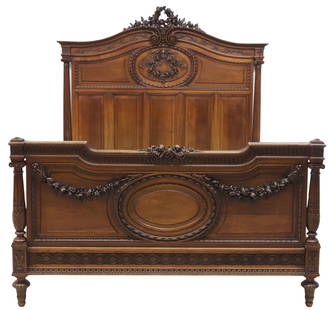 FRENCH LOUIS XVI STYLE FINELY CARVED WALNUT BED: French Louis XVI style walnut bed, early 20th c., arched headboard with profusely carved floral wreath crest over scrolled cornice, guilloche-carved side rails, paneled head and foot boards framed by