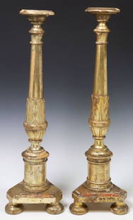 (2) CONTINENTAL BAROQUE STYLE PARCEL-GILT CANDLE PRICKETS: (pair) Continental Baroque style carved wood candle prickets, early 20th c., each gilded only to one side, having turned standard, rising on canted tripartite base, ending on bun feet, approx 27.5&quo