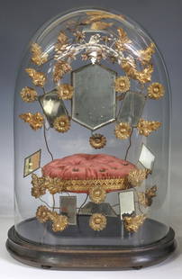 FRENCH GLOBE DE MARIEE / BRIDE'S GLOBE: French globe de mariee/ bride's globe, late 19th c., glass cloche/ dome on ebonized base, encasing gilt metal flowers and beveled mirror plates, on tufted cushion, overall: approx 20.25"h,