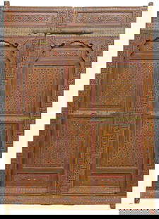 (2) LARGE ARCHITECTURAL MOROCCAN CARVED & PAINTED DOORS, 99"H: (pair) Architectural Moroccan Moresque polychrome-painted doors, 19th c., clad with sheets of studded brass, central recessed mihrab niche-form panel with carved geometrics and painted scrollwork, fra