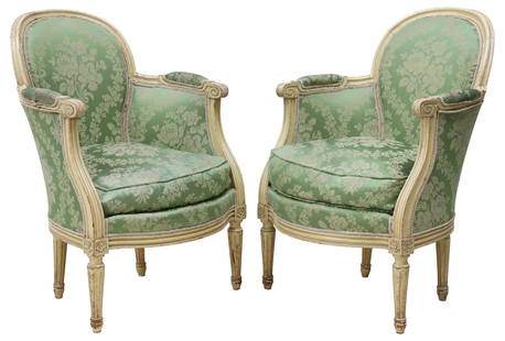 (2) FRENCH LOUIS XVI STYLE SILK-UPHOLSTERED & PAINTED BERGERES: (pair) French Louis XVI style paint-decorated armchairs, 20thc.,&nbsp;each in a cream-painted finish, with green jacquard silk&nbsp;upholstery and applique trim,&nbsp;scrolled handholds, rising on flu