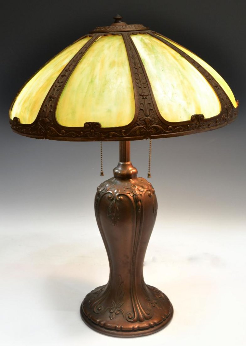 ANTIQUE SLAG GLASS SHADE TABLE LAMP: Antique slag glass two light table lamp, the domed metal shade decorated with foliage and flowers, set with green slag panels, mounted on a foliate and floral decorated urn form having round base, not