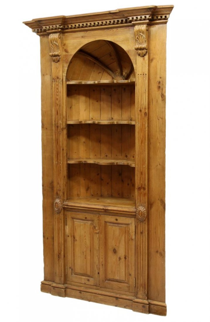 GEORGIAN STYLE PINE CORNER CUPBOARD: British Georgian style pine corner cupboard, 20th c., a stepped cornice over the arched interior niche with four shelves, two lower doors, resting on molded plinth, 84.5"h, 43"w, 16"d Start Price: $40