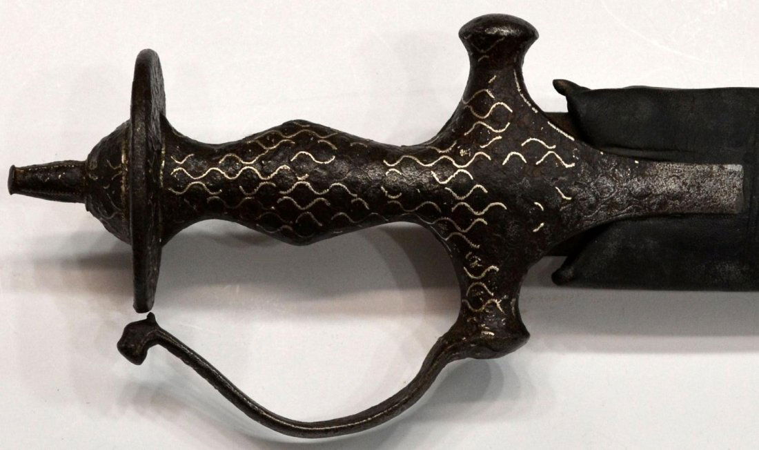 INDO-PERSIAN SWORD & SCABBARD: Indo-Persian sword, 19th c., curved 31.25" blade, the 7.25" hilt with remnants of silver incised decoration, housed in leather covered wood scabbard wood scabbard, overall: 37.75"l, 4.5"w, 2.75lbs Sta