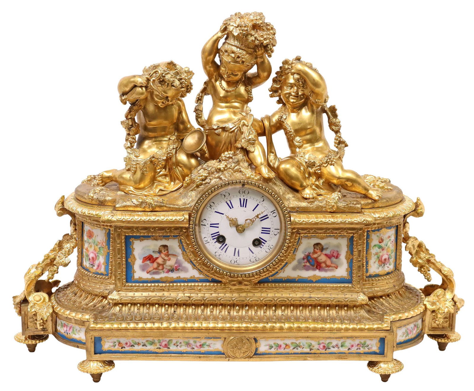 FRENCH SEVRES-STYLE PORCELAIN & ORMOLU PUTTI MANTEL CLOCK: French Louis XVI style bronze dore mantel clock, late 19th c., shaped case surmounted by three Bacchanalian putti, with draped grape vines and wine ewers, inset Sevres style painted porcelain plaques,