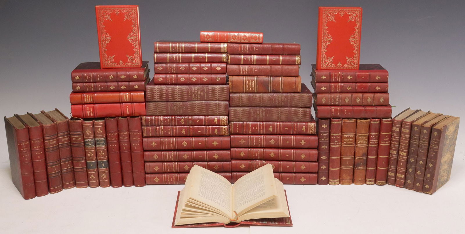 (56) FRENCH LEATHER-BOUND LIBRARY SHELF BOOKS, LITERATURE & RELIGION: (lot of 56) French library shelf books, various literature, drama, history, and religion subjects, all with gilt-embossed red leather binding, many with marbleized covers and raised spine bands, highl