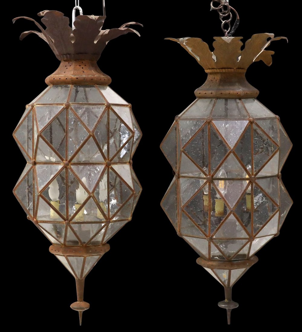 (2) LARGE IRON & GLASS FOLIATE OCTAGONAL 3-LIGHT LANTERNS, MEXICO: (pair) Large patinated iron and glass three-light hanging lanterns, Mexico, each having flared foliate ceiling mount, above waisted octagonal frame, terminating on pointed drop finial, hinged access d